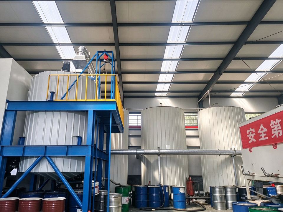 Blending kettles on a steel platform with agitator drives and base stocks at floor level