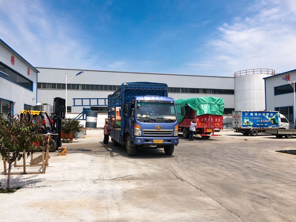 Trucks being loaded with drums and pails in the dispatch yard